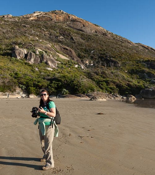 female photographer with camera on beach